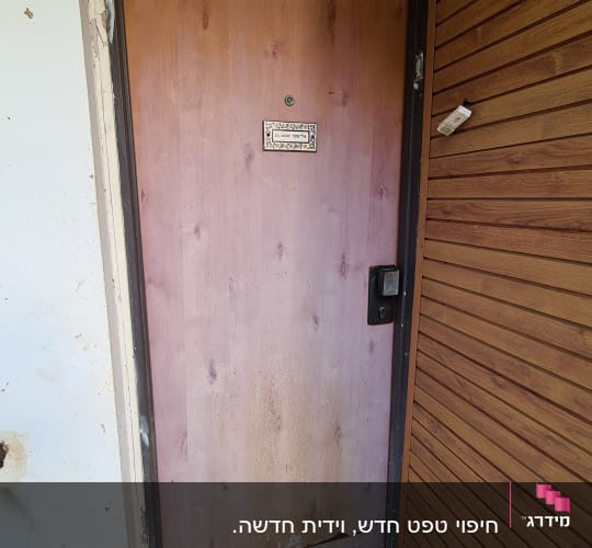 דלת עץ עם סימני שחיקה וידית שחורה
